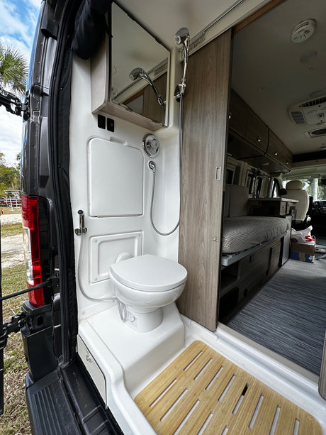 This RV rental's rear interior boasts a functional wet bath with toilet & shower, and a clean living area. Ready for adventure.