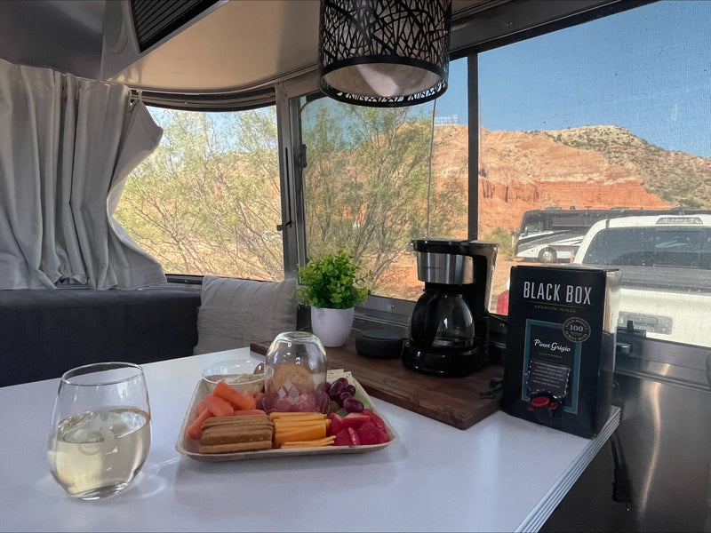 Enjoying an RV rental: a cozy setup with wine, coffee, snacks, and a stunning desert mountain view, including other RVs. — photo 5