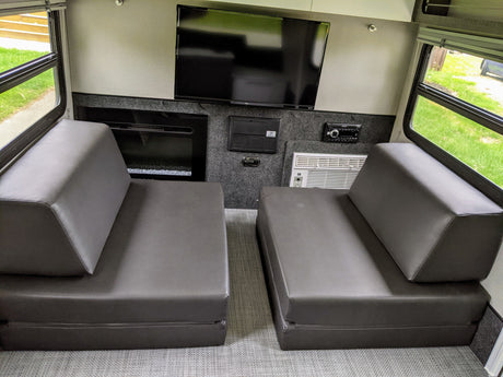 RV rental interior: comfy modular seating, entertainment (TV, stereo, fireplace), and AC. Perfect for mobile comfort.