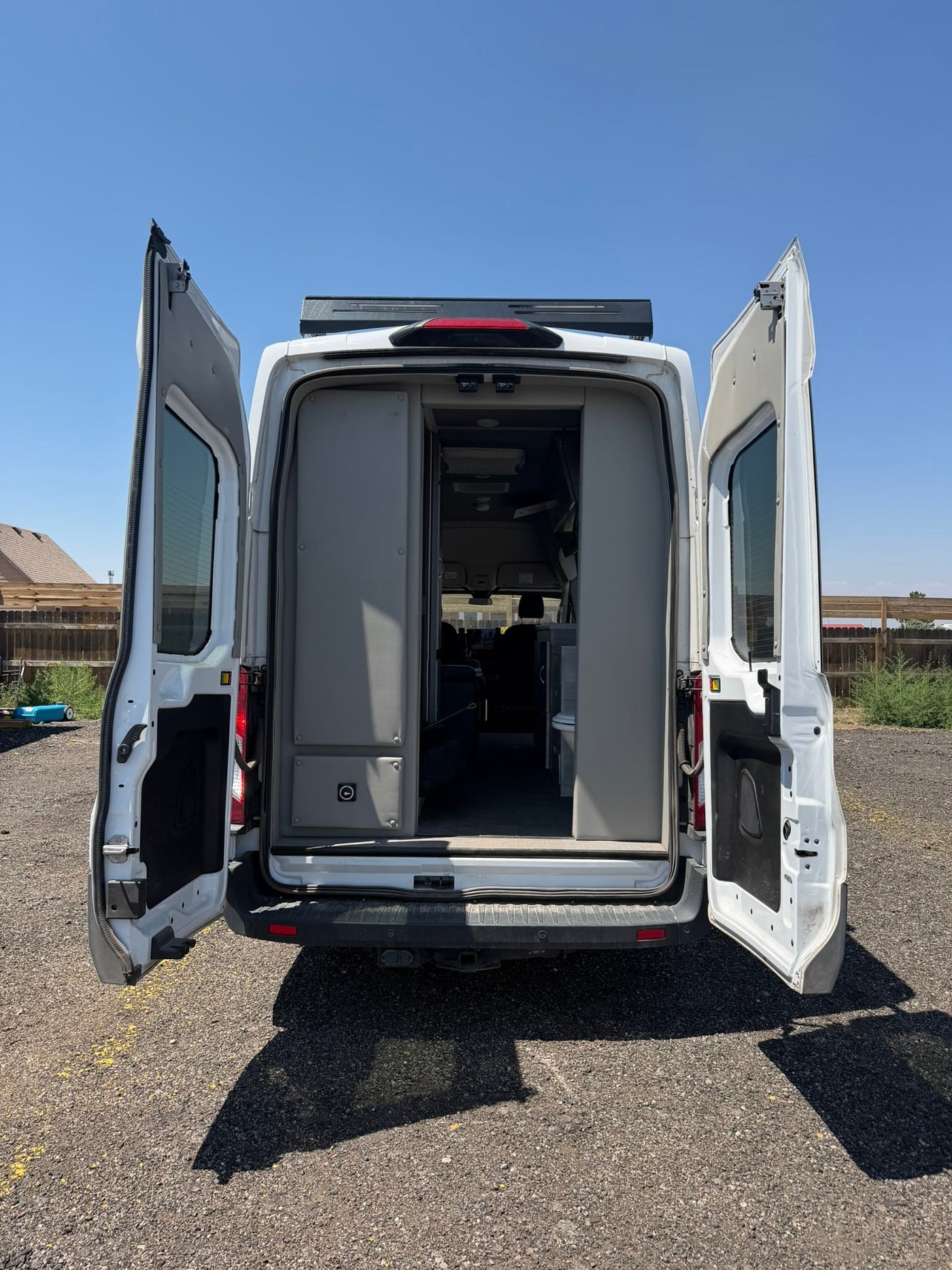 with a window view of another parked RV.|Rear view of a white **rv rental** camper van with open doors — photo 3