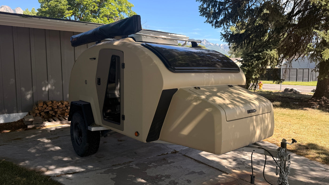  parked on a driveway.|A tan Scapoda teardrop trailer — photo 14