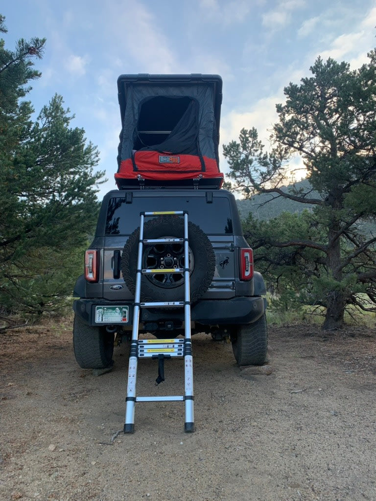 Explore with this Ford Bronco RV rental! Equipped with a rooftop tent and ladder, it's perfect for your next camping adventure.