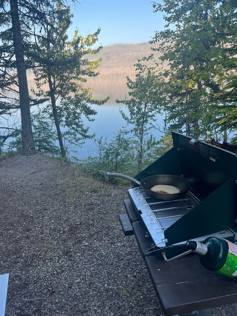 An RV rental adventure cooking a lakeside breakfast on a camping stove. Peaceful morning by the water. — photo 6