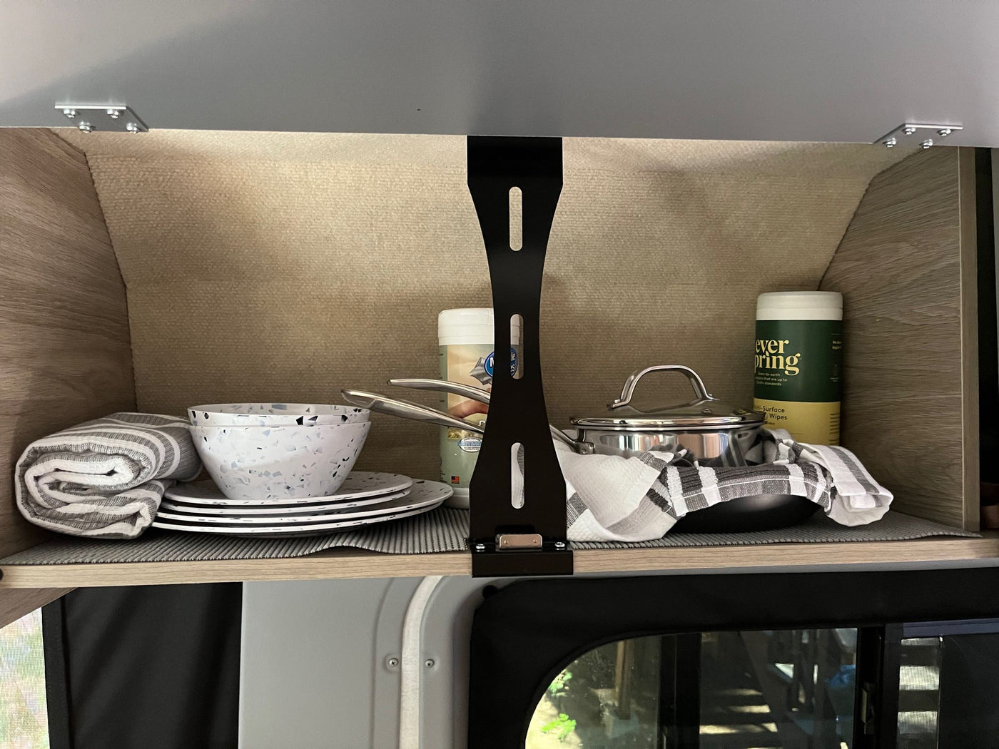  illuminated by bright side lights against a dark forest background.|White RV rental parked at a serene wooded campsite — photo 9
