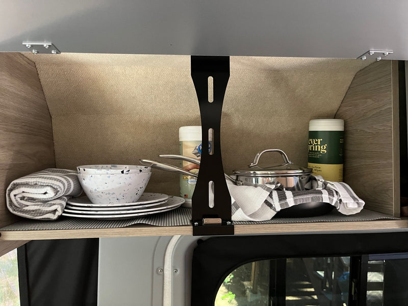  illuminated by bright side lights against a dark forest background.|White RV rental parked at a serene wooded campsite — photo 9