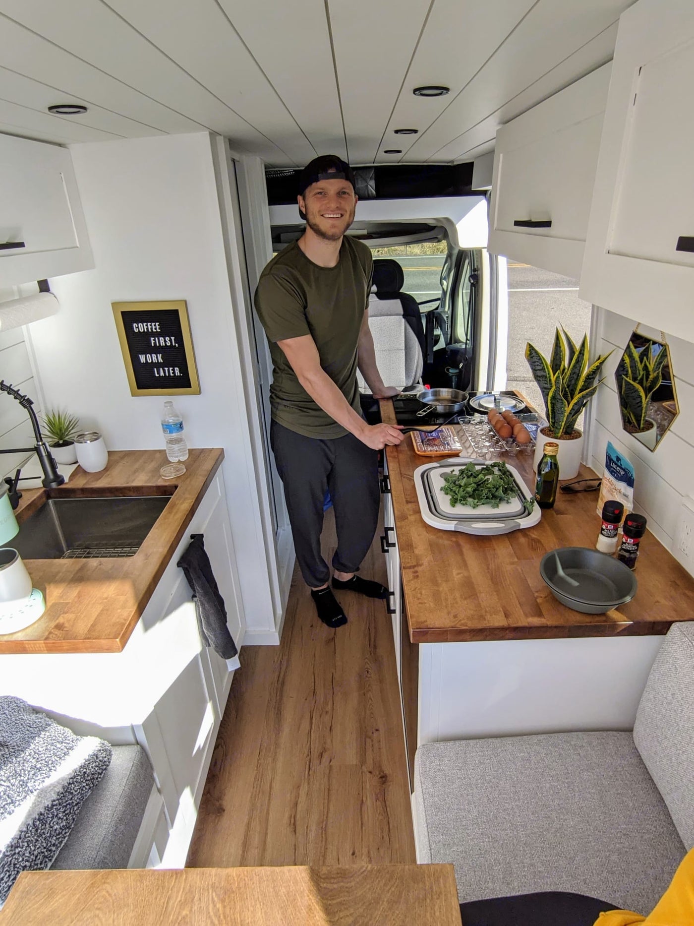  ideal for RV rental journeys.|Inside an RV rental: a comfy bed with a large projector screen displaying apps like Netflix and YouTube for ultimate entertainment.|Spacious RV rental interior: white kitchen — photo 3