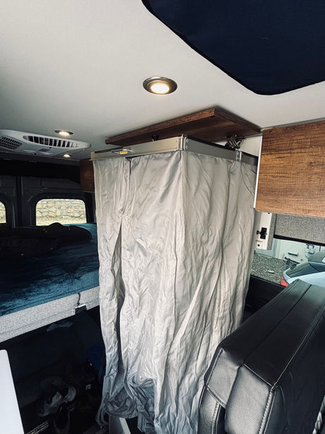Explore this RV rental's compact interior with a cozy bed & a convenient shower curtain.