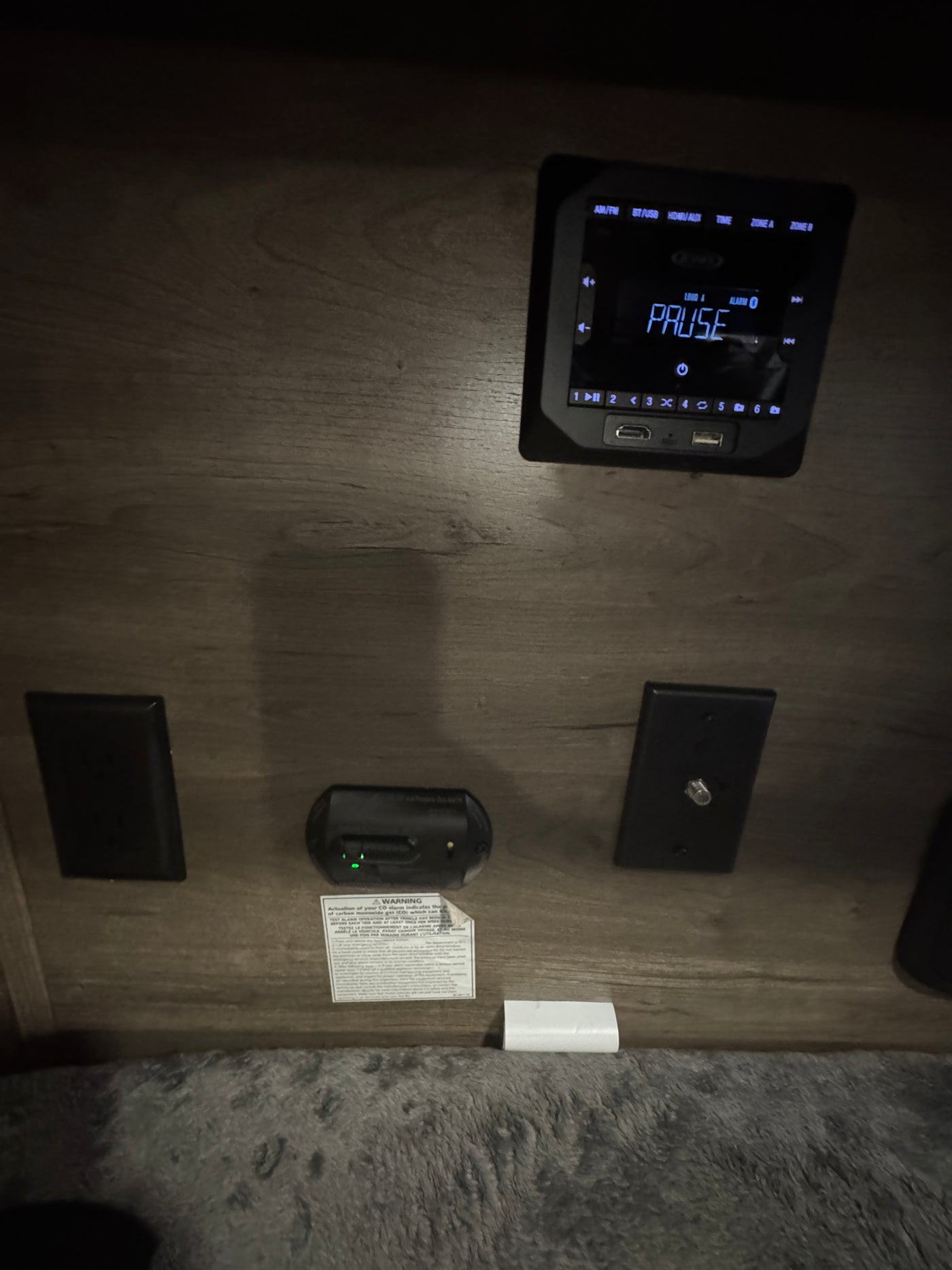 RV rental interior featuring a media player with USB/HDMI ports, a CO alarm, and cable input for entertainment and safety. — photo 8