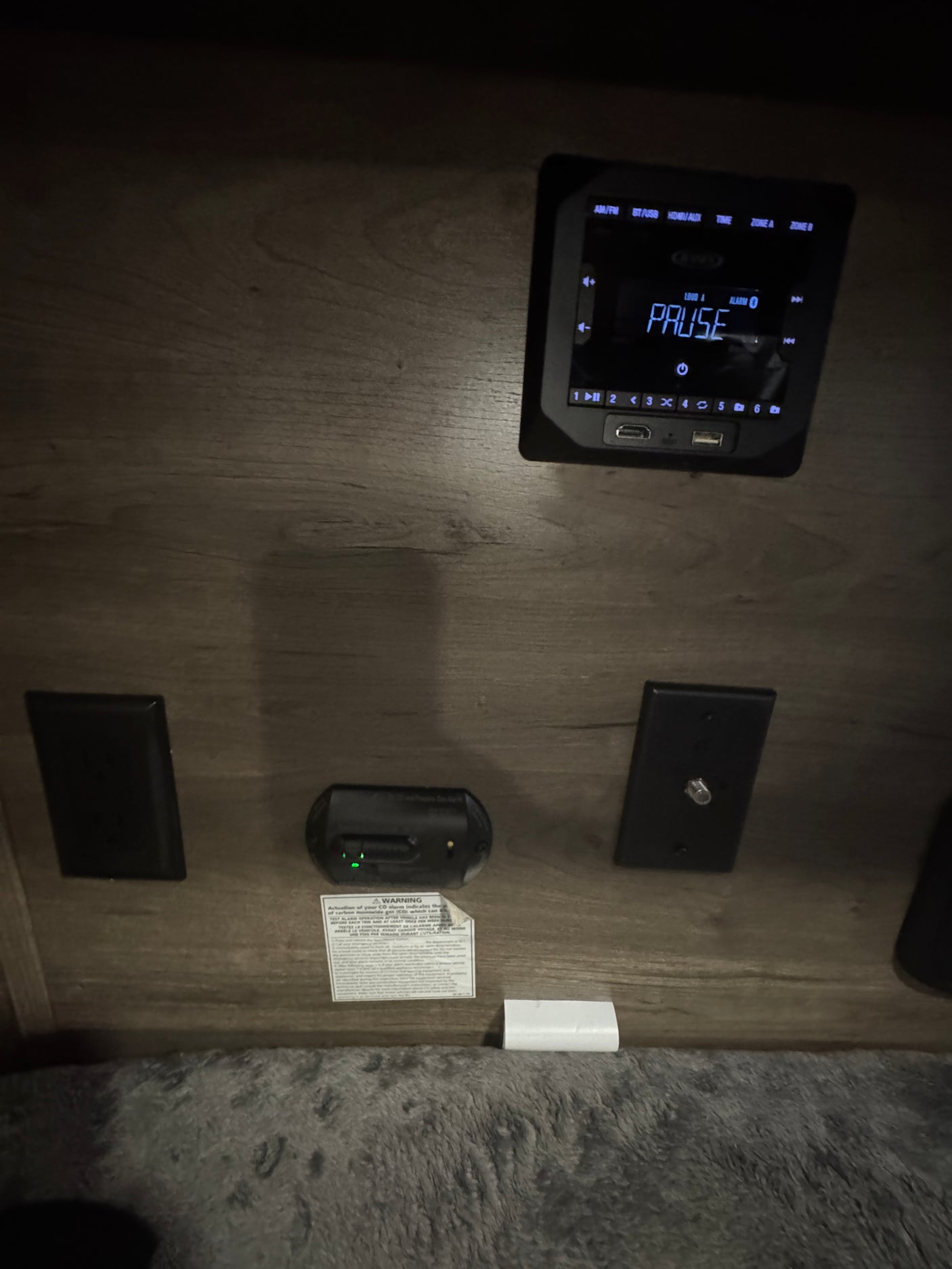 RV rental interior featuring a media player with USB/HDMI ports, a CO alarm, and cable input for entertainment and safety.