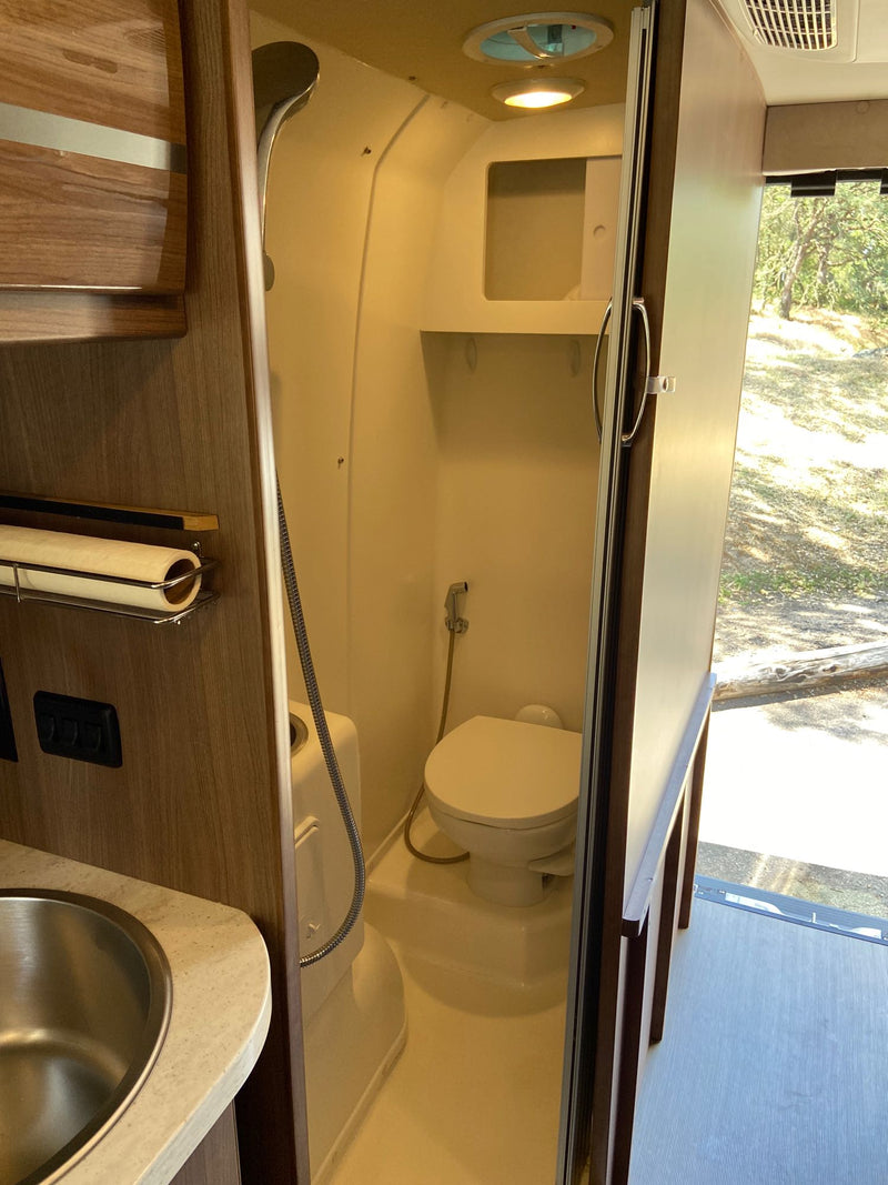  plus a space-saving tambour shower enclosure.|Step inside this RV rental: a compact and organized space with a full bathroom — photo 16