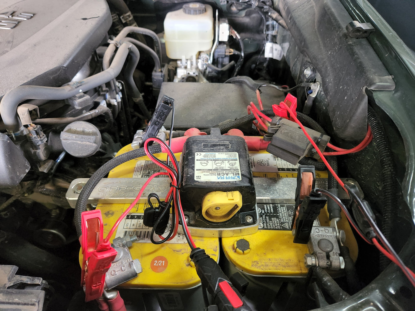Dual battery setup in a vehicle engine bay, showing an Optima battery & charging relay. Ideal for RV rental trips.