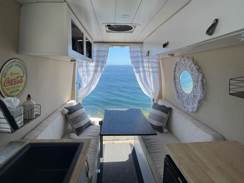 Inside an RV rental camper van: A cozy dining area, kitchen, and incredible ocean views out the back. — photo 2