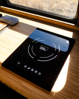 Sleek induction cooktop in an RV rental, set on a bright wooden counter. Ideal for camper kitchen cooking.