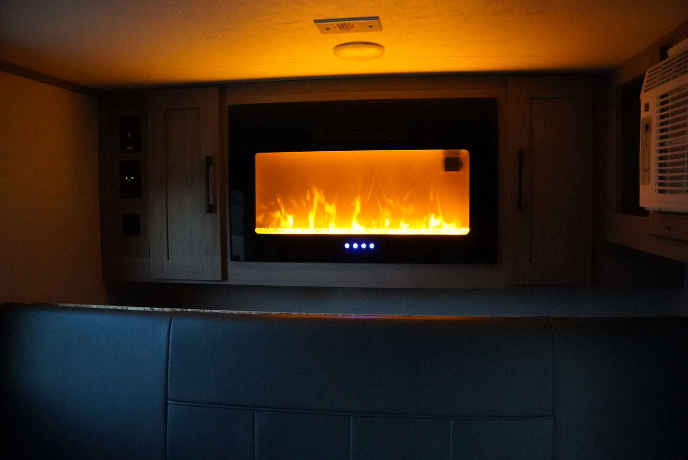 Relax in your RV rental! This cozy interior features a bright electric fireplace for warmth and ambiance.