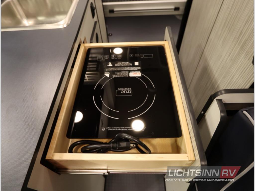 RV rental's compact kitchen features a pull-out induction cooktop for easy cooking and clever storage.
