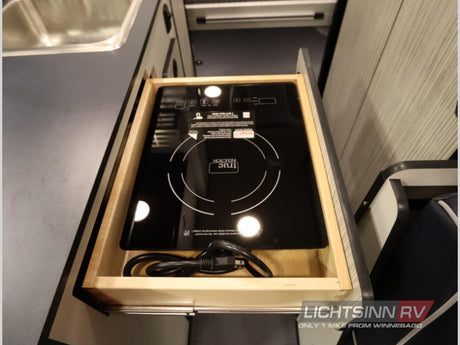 RV rental's compact kitchen features a pull-out induction cooktop for easy cooking and clever storage.