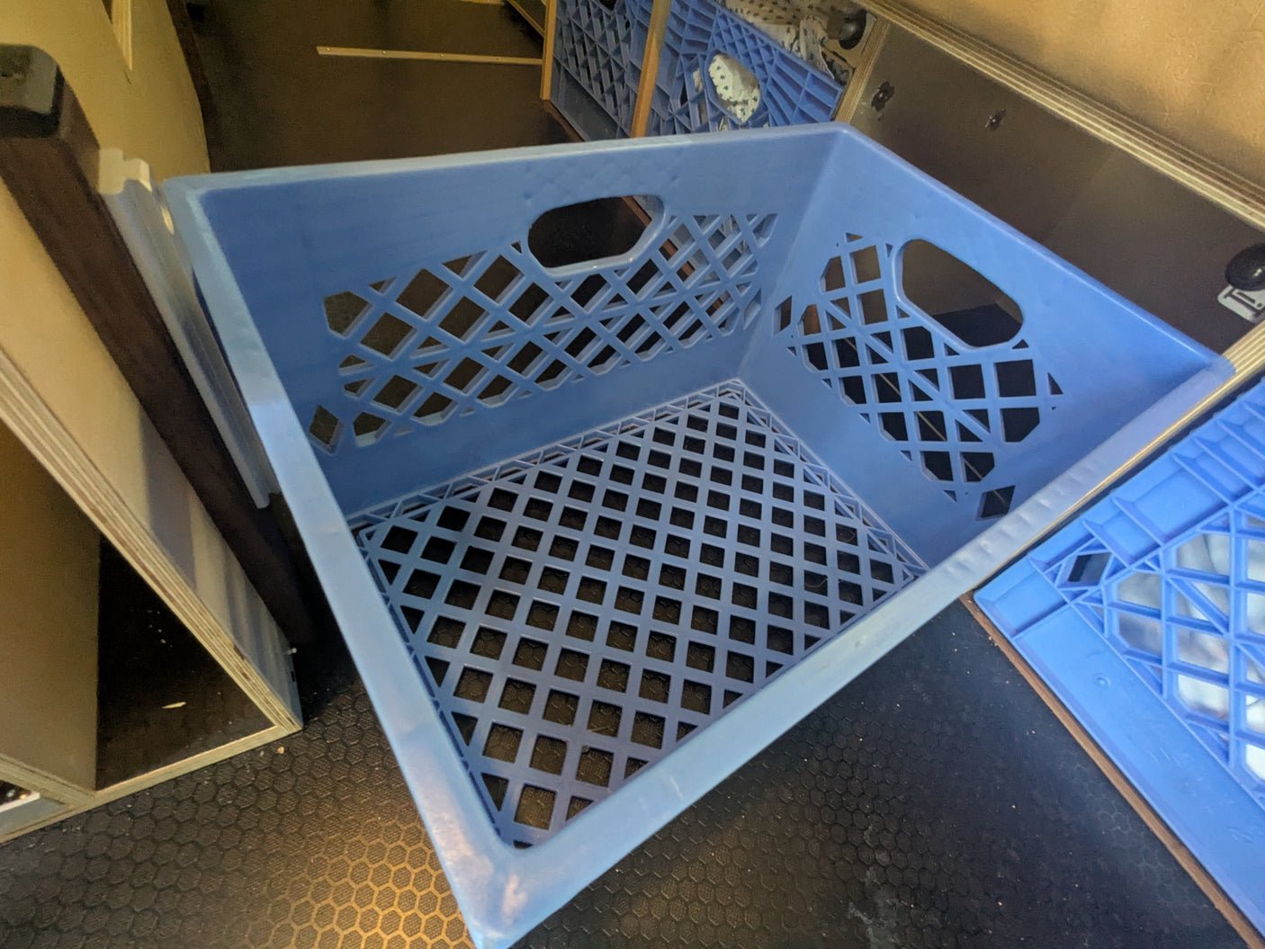 Blue plastic storage crates inside an RV rental, offering versatile organization for your next camper adventure.