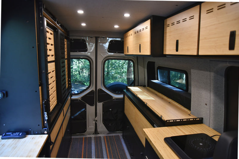 Explore this modern RV rental interior: custom wood, functional storage, kitchenette, and inviting forest views. — photo 7