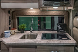 Compact RV rental kitchen with a sleek sink, two-burner cooktop, and counter space for preparing meals.