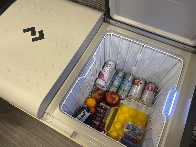 An open rv rental portable fridge filled with sparkling drinks, sodas, fresh fruit, yogurt, and cheese/salami snacks. — photo 20