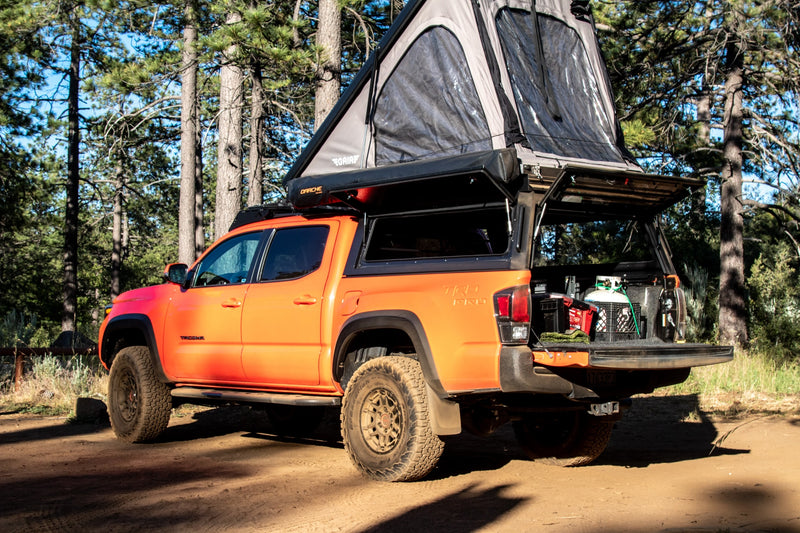  equipped with a rooftop tent & awning. A ready RV rental for your next outdoor adventure.|Orange Toyota Tacoma pickup truck with rooftop tent — photo 3