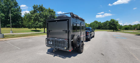 Off-road ready RV rental: A compact travel trailer hitched to a pickup, perfect for camping adventures.