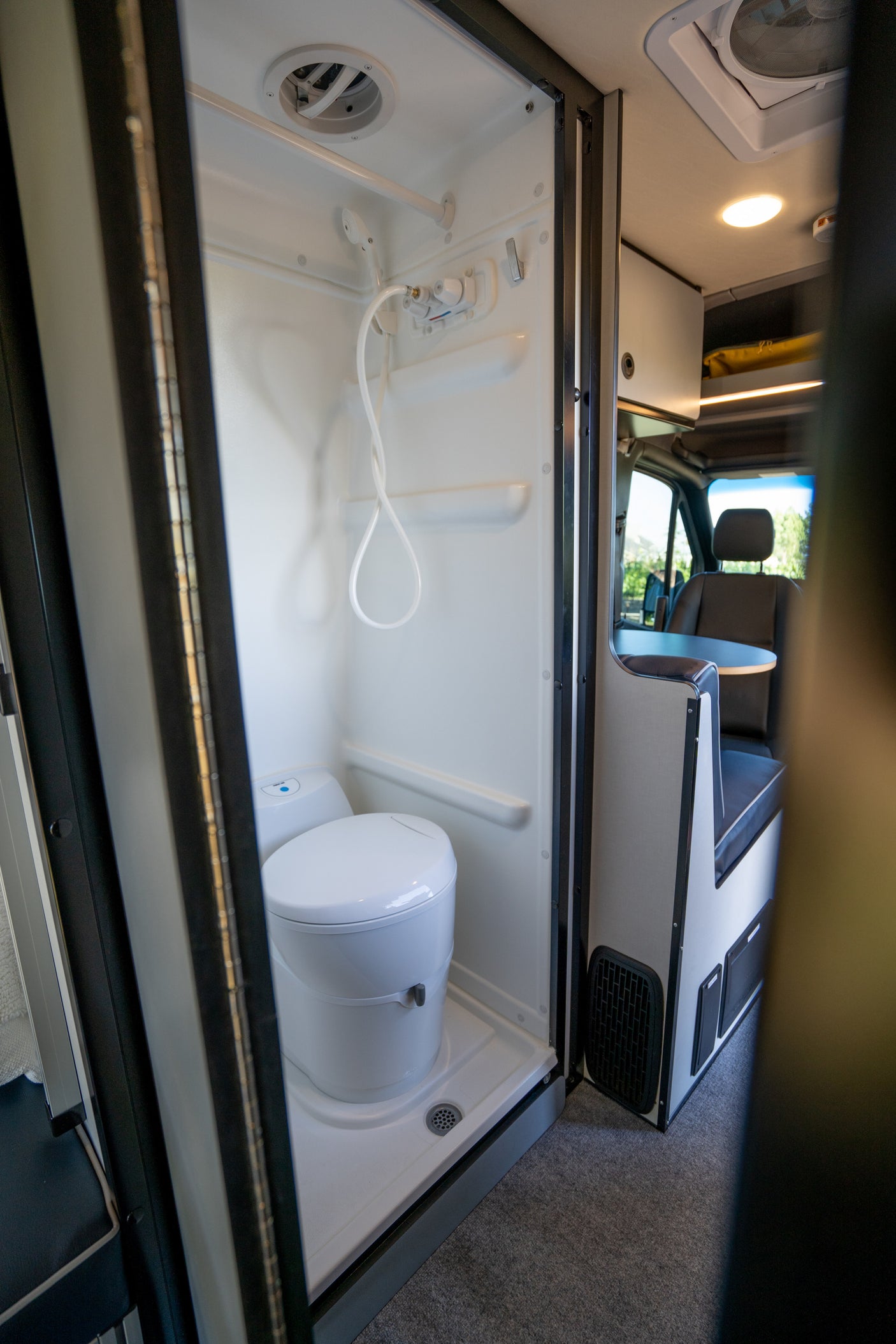Step inside this RV rental's compact bathroom, featuring a functional shower and toilet setup for convenient travel.