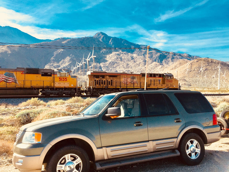  and digital temperature display.|A black SUV parked in a rocky desert with cacti under a cloudy sky. Your journey could begin with an rv rental.|An Arizona DeLorme map atlas in an RV rental door pocket — photo 11