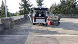 Silver camper van with solar panel & cargo box, parked outdoors. Likely an RV rental setup, ready for adventure.