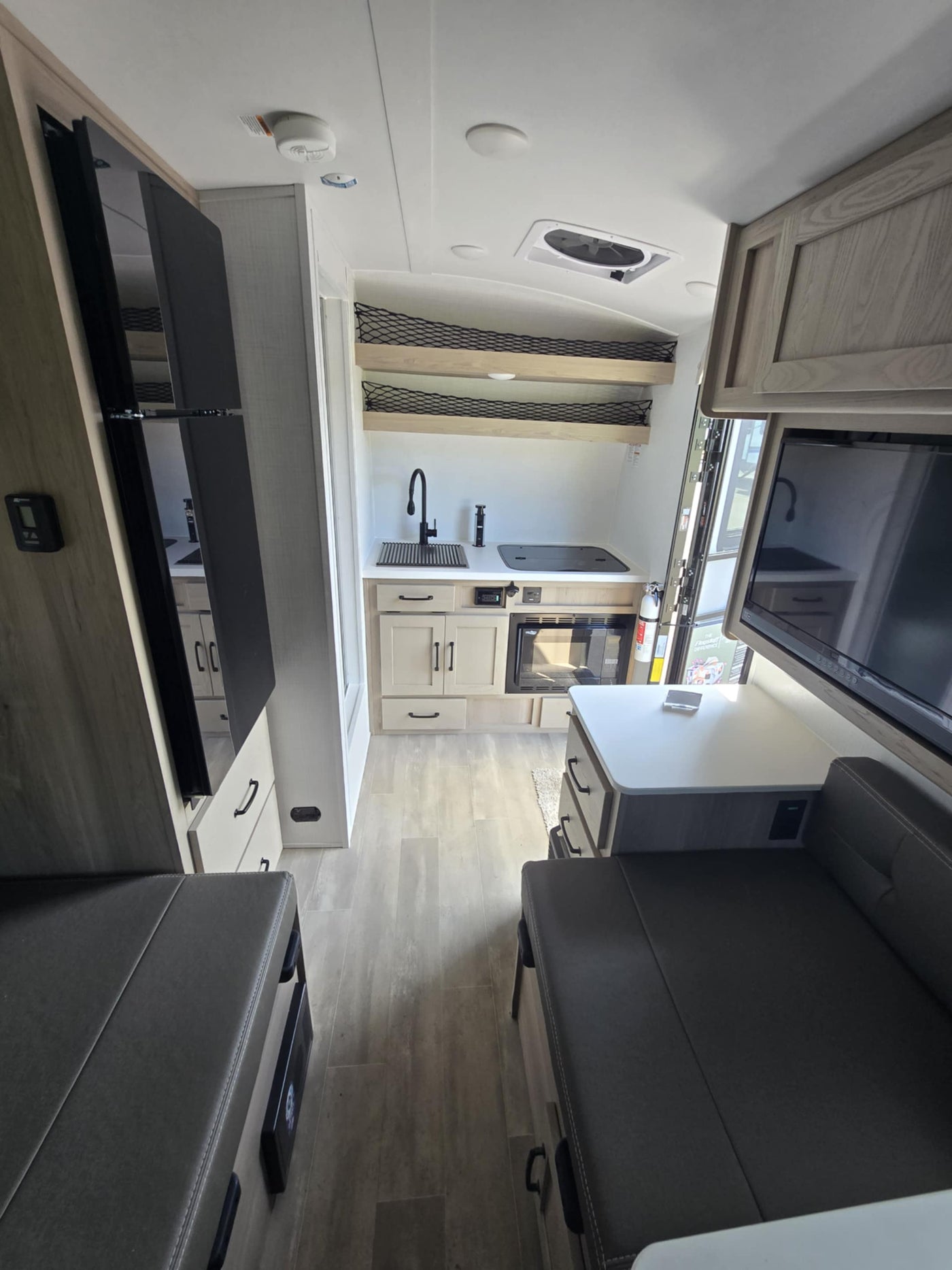  features a prominent front bike rack and propane tanks.|Inside an RV rental: modern kitchenette — photo 4