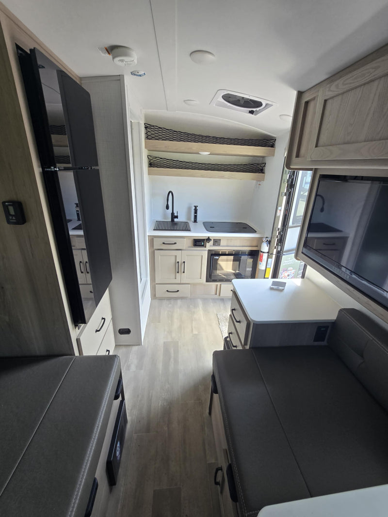  features a prominent front bike rack and propane tanks.|Inside an RV rental: modern kitchenette — photo 4