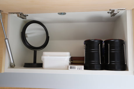 RV rental cabinet essentials: A mirror, playing cards, and camping lanterns for your comfortable journey.