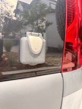 RV rental's Furrion 30Amp 125V shore power inlet, mounted on the vehicle's dark rear panel near a red taillight.