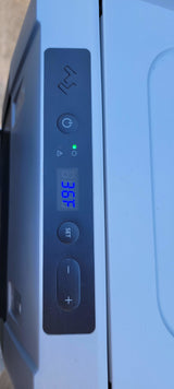 Portable fridge control panel in an RV rental: 39.6°F displayed, with power (green light), set, and temp adjustment buttons.