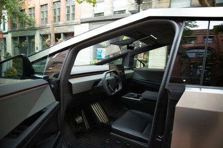 Interior of a Tesla Cybertruck: a futuristic EV with a yoke steering wheel, minimalist dashboard, and sleek design. Not an rv rental.