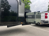 Hiker Trailer RV rental: A gray Truma portable fridge is pulled out on a Dometic slide from the side of the trailer. Ideal camping setup.