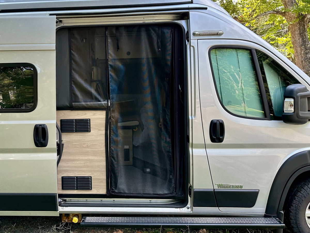  is parked with a leveling mat for your next adventure.|Rear view of a silver Winnebago Solis RV rental — photo 7