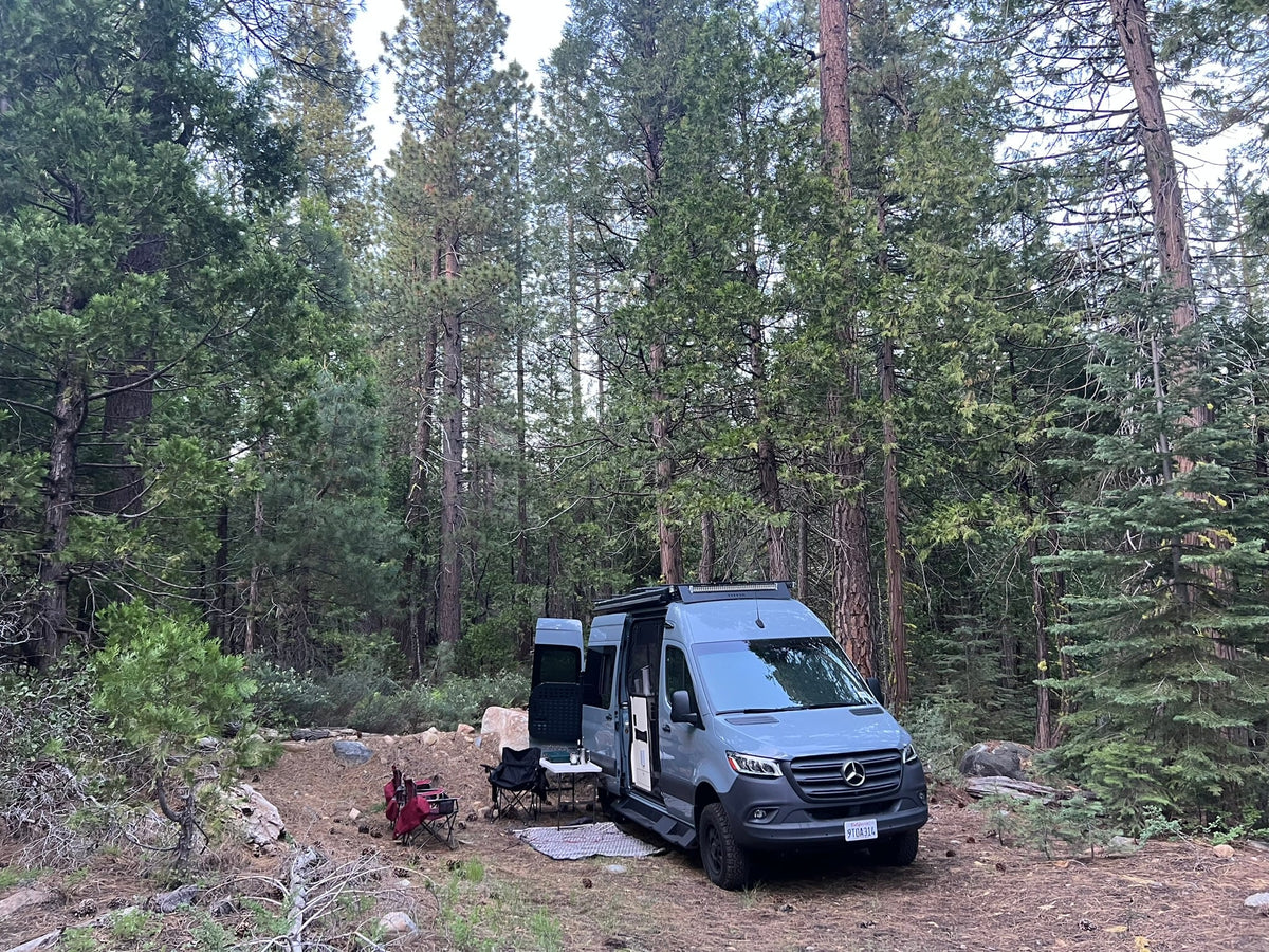  and mirror. Features a space-saving design for travel accommodation.|Three dogs paddleboarding on a calm lake with a forest backdrop. Perfect pet-friendly RV rental adventure!|This gray Mercedes Sprinter RV rental — photo 14