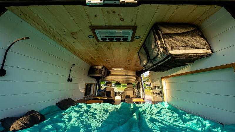 Cozy rv rental camper van interior with a teal bed, wooden ceiling, and front cabin view, perfect for road trips. — photo 11