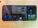 RV rental power control panel: Victron Energy Multi Control, Eberspächer heater, and timer switches mounted on wood.