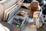 Compact fridge/freezer storage in an RV rental, packed with food for travel adventures. Perfect for van life.