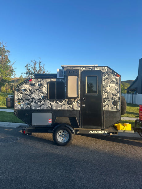 Check out this unique camo Karavan off-road rv rental trailer, perfect for rugged camping adventures. Features an AC unit & spare tire.