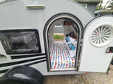 Step inside this cozy teardrop trailer, perfect for your next RV rental adventure. The bed features fun car-themed bedding.