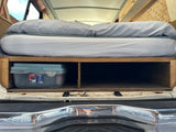 RV rental interior: Comfortable bed elevated over wooden storage compartments, holding a Hefty HI-RISE bin. Perfect for organizing travel gear.