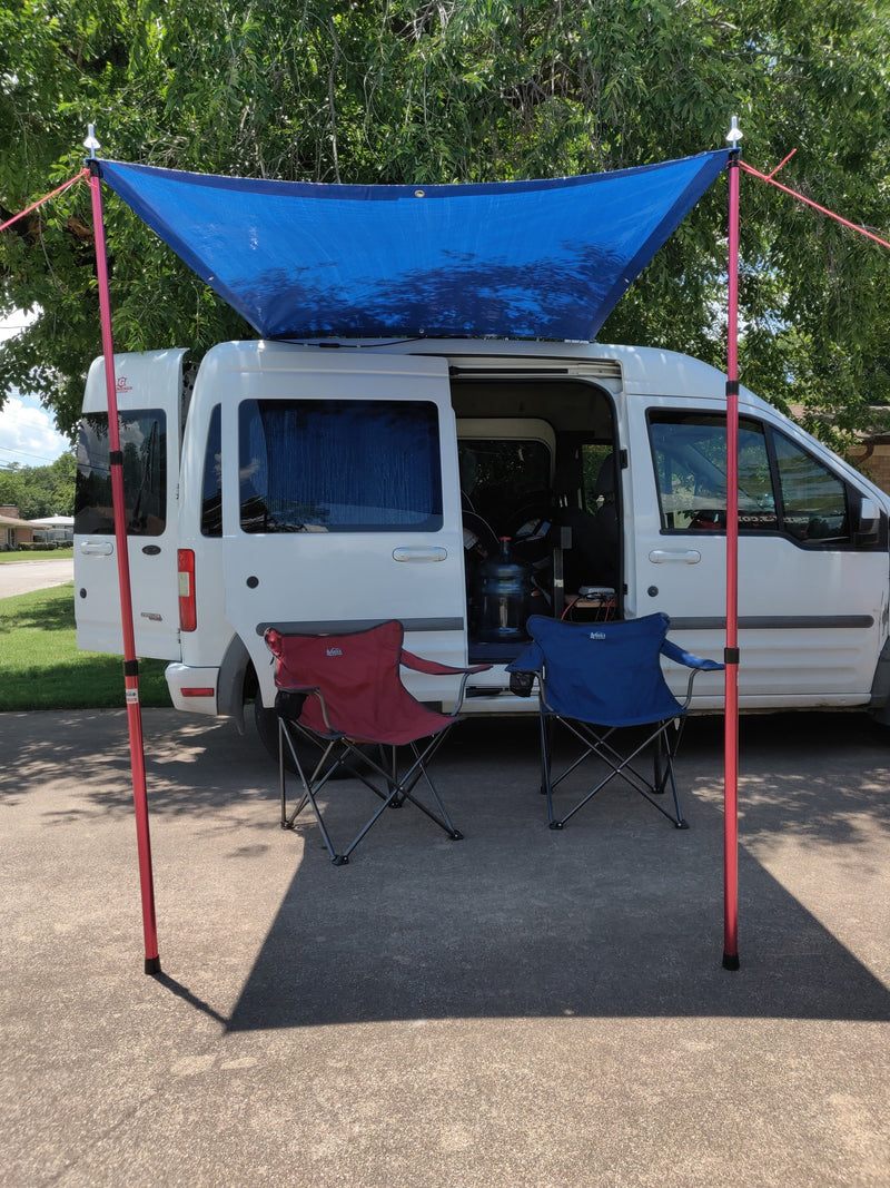 An RV rental camper van with a blue awning and chairs, creating a cozy outdoor camp setup. — photo 3
