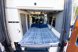 Cozy RV rental interior with a comfy bed, perfect for your next road trip adventure in this camper van.