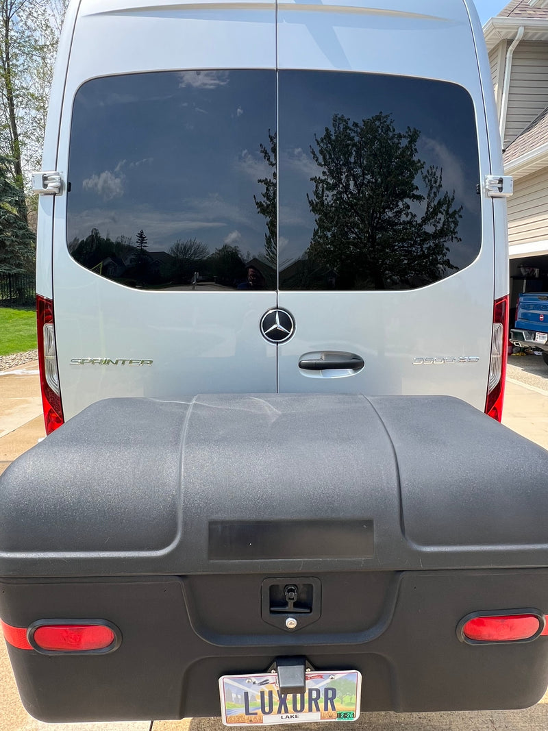 Rear of silver Mercedes Sprinter van with large black cargo box & custom 'LUXURR' plate. An excellent rv rental option. — photo 5