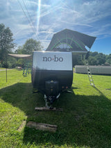 Explore with this rv rental: a no bo travel trailer featuring a rooftop tent & awning, perfect for camping adventures.