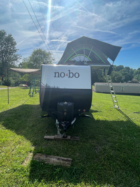 Explore with this rv rental: a no bo travel trailer featuring a rooftop tent & awning, perfect for camping adventures.