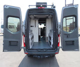 Dark gray RV rental camper van, rear view with open doors showing its spacious, customized interior with storage units.